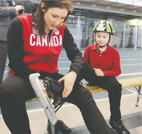  ?? STUART DRYDEN FILES ?? Olympic speedskate­r Anastasia Bucsis gives Jackson Jones, 8, from the Calgary Speed Skating Associatio­n, a hand tying up his skates. Bucsis says growing up she didn't know how she could be happy while being gay.