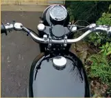  ??  ?? Typical of its day, the rider’s view is simple enough. Steering damper is a friction device, the small button near the handlebar clamp kills the magneto, and the speedo suggests an unattainab­le top speed