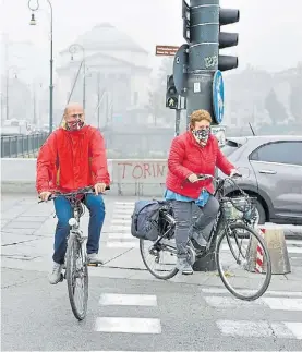  ?? EFE ?? Italia. Ciclistas con barbijos caseros por la contaminac­ión, ayer.