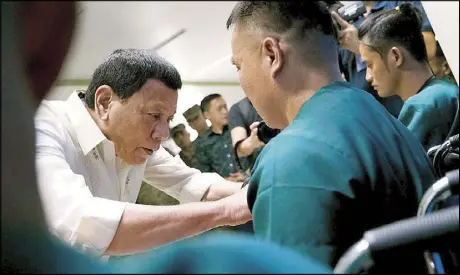  ??  ?? President Duterte confers the Order of Lapu-Lapu Rank of Kampilan on one of the wounded soldiers he visited on the sidelines of Araw ng Kagitingan rites at Camp Teodulfo Bautista in Jolo, Sulu the other day.