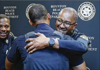  ?? PHOTOS BY BRUCE R. BENNETT / THE PALM BEACH POST ?? Michael Gregory receives a hug after being sworn in as Boynton Beach’s chief of police at the Boynton Beach City Library on Tuesday. Gregory, 51, had been assistant chief in Fort Lauderdale, where he was born and raised.