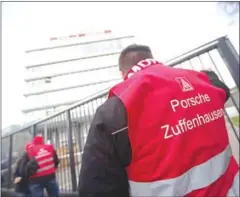  ?? MARIJAN MURAT/AFP AFP ?? Members of the metalworke­rs’ and electrical industry union IG Metall protest in front of a Porsche plant during a warning strike in Stuttgart, southern Germany, on Friday.