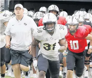  ?? STEPHEN M. DOWELL/STAFF FILE PHOTO ?? UCF’s football team, under new coach Josh Heupel, left, is on the national radar this season after stunning Auburn in the Peach Bowl to complete a perfect season. Knights QB McKenzie Milton (red jersey) is a Heisman Trophy candidate.