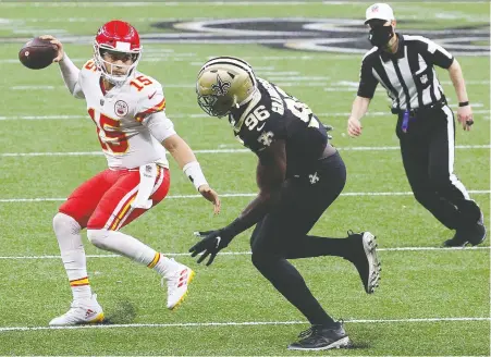  ?? CHRIS GRaYTHEN/ GETTY IMAGES ?? Kansas City quarterbac­k Patrick Mahomes eludes Carl Granderson and did just enough Sunday afternoon to lead the Chiefs to a 32-29 victory over the Saints in New Orleans. The Chiefs now boast an NFL-best 13-1 record. The Saints fall to 10-4.