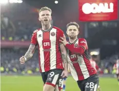  ?? ?? Sheffield United striker Oli Mcburnie, left, celebrates scoring a 103rd-minute penalty to earn a 2-2 draw against West Ham