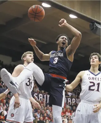  ?? Marcio Jose Sanchez / Associated Press ?? Gonzaga’s Johnathan Williams celebrates his dunk in front of Jock Landale (34) and Evan Fitzner of St. Mary’s. Williams and the Zags dealt the Gaels their first WCC loss.