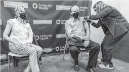  ?? William Luther / Staff photograph­er ?? Bexar County Judge Nelson Wolff, center, gets vaccinated and rocks a mask in December. He's trying to keep San Antonians healthy and free from COVID, so quit harassing him.