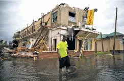  ?? ERIC THAYER/NEW YORK TIMES ?? LEFT: A man walks near a damaged apartment building in Panama City, Fla., following Hurricane Michael. The Category 4 storm charged through Florida and into Georgia on Wednesday, lashing the Panhandle with rains and heavy winds.