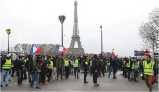  ?? -AFP ?? PROTEST AGAINST RISING OIL PRICES: Protestors wearing ‘Yellow vests stand near the river Seine as the Eiffel tower is seen, during a protest of against rising oil prices and living costs on December 8, 2018 in Paris.
