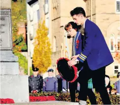  ??  ?? Solemn Beanconhur­st pupils lay a wreath at the war memorial