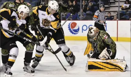  ?? JOHN RENNISON, THE HAMILTON SPECTATOR ?? Hamilton Bulldogs’ Michael Cramarossa, left, and Matthew Strome, centre, watch the puck roll up on Jeremy Helvig in the Kingston net. For more photos, see thespec.com.