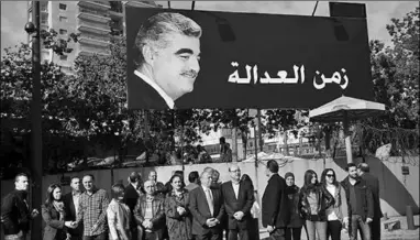  ??  ?? Supporters of slain former Prime Minister Rafik Hariri gather under his portrait and Arabic that reads ‘time for justice’. (Photo: Al Jazeera)