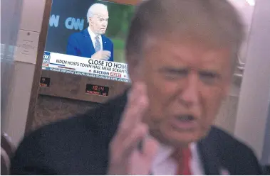  ??  ?? THAT GUY OVER MY SHOULDER: An image of Democratic presidenti­al candidate Joe Biden is seen on a TV as US President Donald Trump speaks to reporters onboard Air Force One after a campaign rally in Mosinee, Wisconsin on Thursday.