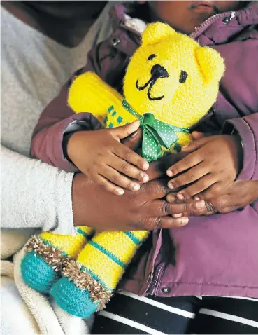  ?? Picture: Esa Alexander ?? A mother comforts her three-year-old daughter, who is clutching her teddy bear, after repeatedly trying to report the girl’s rape at police stations in Cape Town last weekend.