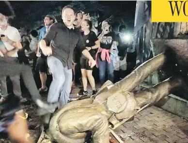  ?? JULIA WALL / THE NEWS & OBSERVER VIA AP ?? Protesters celebrate after the Confederat­e statue known as “Silent Sam” was toppled on the campus of the University of North Carolina in Chapel Hill, N.C., during a demonstrat­ion on Monday.