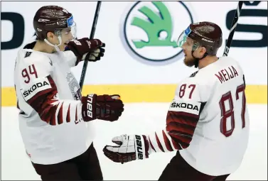  ?? AP PHOTO / PETR DAVID JOSEK ?? Latvia's Gints Meija, right, celebrates with teammate Kristians Rubins, left, after scoring his sides first goal during the Ice Hockey World Championsh­ips group B match between South Korea and Latvia at the Jyske Bank Boxen arena in Herning, Denmark,...