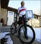  ?? JENNY SPARKS — LOVELAND REPORTERHE­RALD ?? Bill Wallace poses for a photo with his Guinness World Records certificat­e, his bike and a photo book Friday, outside his home in Berthoud.