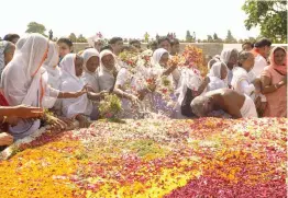  ?? — PRITAM BANDYOPADH­YAY ?? Widows from Vrindaban pay floral tribute at Mahatma Gandhi’s memorial at Rajghat in New Delhi on Tuesday.