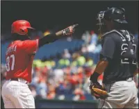  ?? The Associated Press ?? THERE IT GOES: Philadelph­ia Phillies’ Odubel Herrera, left, reacts next to Atlanta Braves catcher Kurt Suzuki after Herrera hit a three-run home run during the third inning Monday in Philadelph­ia.