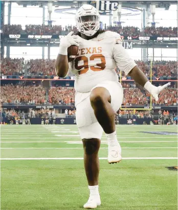  ?? TOM FOX/THE DALLAS MORNING NEWS VIA AP ?? DL T’Vondre Sweat celebrates after catching a TD pass during Texas’ victory in the Big 12 championsh­ip on Saturday. The thirdranke­d Longhorns will face No. 2 and unbeaten Washington in the CFP semifinals.