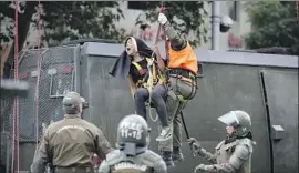  ?? Victor R. Caivano Associated Press ?? POLICE DETAIN an activist dressed as a nun after she and other protesters suspended an abortion-rights banner along Pope Francis’ route in Santiago, Chile.