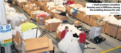  ?? Robert Melen ?? &gt; Staff members Jonathan Beasley and Jo Williams among the wedding dresses for sale