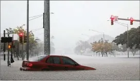  ?? MARIO TAMA / GETTY IMAGES ?? A car is partially submerged in floodwater­s from Hurricane Lane rainfall in Hilo on the Big Island. The island remained under a flash flood warning Thursday.