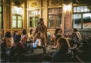  ?? Foto: Lukas Salna, MDR, UFA Fiction, ARD, dpa ?? Kruso (Albrecht Schuch) spricht auf der Terrasse des „Klausner“auf Hiddensee mit Schiffbrüc­higen. Der Film ist eine Verfilmung des starken Romans von Lutz Seiler.