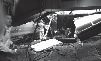  ?? PRESS
ASSOCIATED ?? In a photo provided by William Sun, people examine the wreckage of a New Jersey Transit commuter train that crashed into the train station during the morning rush hour in Hoboken, New Jersey. The crash caused an unknown number of injuries and witnesses...