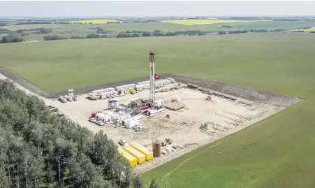  ?? JEFF McINTOSH, THE CANADIAN PRESS ?? An oil drilling rig operates surrounded by canola and hay fields near Cremona, Alta.