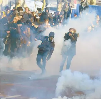  ??  ?? Un francés avienta una granada de gas lacrimógen­o en las protestas por la reforma de pensiones, en Burdeos.