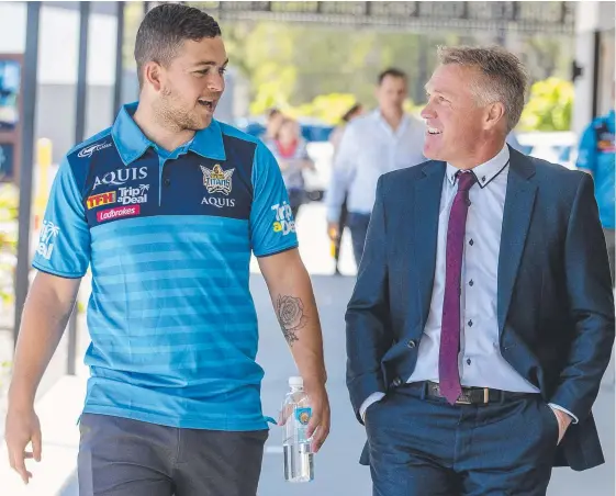  ?? Picture: JERAD WILLIAMS ?? Ash Taylor talks with Titans coach Garth Brennan yesterday before addressing the star half’s new contract with the club.