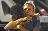  ?? Cody Glenn / Special to the Chronicle ?? Women hug at Gavilan College’s Gilroy campus, the reunificat­ion site for people who escaped the shootings.