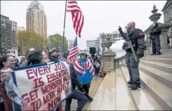  ?? MATTHEW DAE SMITH / LANSING STATE JOURNAL VIA AP ?? Protesters rally in April to denounce Gov. Gretchen Whitmer's stay-home order and business restrictio­ns due to COVID-19, at the state Capitol in Lansing, Mich.