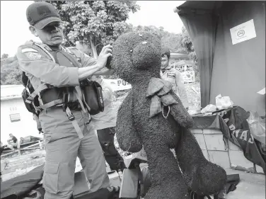  ?? JON NST / AGENCE FRANCE-PRESSE ?? A member of the search team shows a doll recovered near the site of the boat that capsized at Lake Toba in Simalungun, Indonesia,
on Monday.