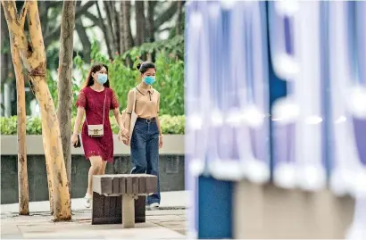  ??  ?? Women wear facemasks amid fears of the COVID-19 novel coronaviru­s in the Orchard Road shopping district in Singapore on March 10, 2020. (Photo by Louis KWOK / AFP)