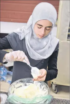  ?? FRAM DINSHAW/THE NEWS ?? Manar Almetheb, a New Glasgow local originally from Daraa, Syria, prepares food at Culture Days on Saturday.