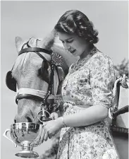  ?? ?? 1944
The then Princess Elizabeth feeds a horse from a trophy after it claimed first prize at the Royal Windsor Horse Show