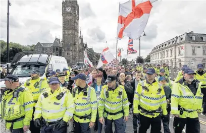  ??  ?? Police on duty at the English Defence League demonstara­tion in Rochdale in July – but figures show the number of officers in the borough has been slashed by almost a quarter in recent years