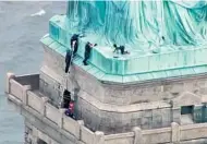  ?? GETTY IMAGES ?? A still image taken from video courtesy of PIX11 News in New York shows police talking to the woman who climbed up to the base of the Statue of Liberty on July 4.