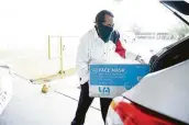  ??  ?? U.S. Rep. Al Green loads up a car with medical masks donated by the Internatio­nal Management District through its coronaviru­s task force.