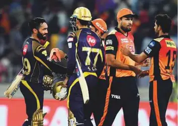  ?? AFP ?? Kolkata Knight Riders captain Dinesh Karthik (left) reaches out to Sunrisers Hyderabad players after securing a crucial victory in Hyderabad on Saturday.