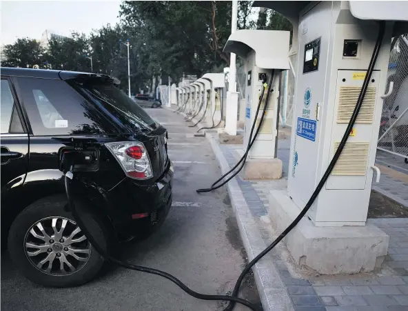  ?? — GETTY IMAGES FILES ?? With charging stations like this one in Beijing, China is gearing up to ban gasoline- and diesel-powered cars. David Booth estimates the cost of higher-speed charging stations to be between $25 million and $40 million apiece just for the equipment.