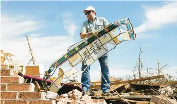  ?? ROGELIO V. SOLIS/AP ?? Charlie Weissinger searches through the rubble of the Chapel of the Cross Episcopal Church on March 29 in Rolling Fork, Miss.