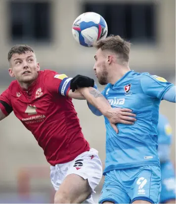  ??  ?? Sam Lavelle of Morecambe and Sam Smith of Cheltenham have an aerial duel at the Globe Arena