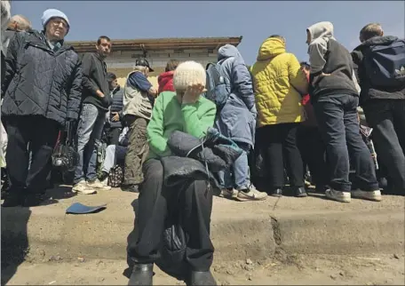  ?? Carolyn Cole Los Angeles Times ?? PEOPLE wait in line for food assistance at Ark Church in Kharkiv, Ukraine. The city has been under Russian bombardmen­t since Feb. 24.