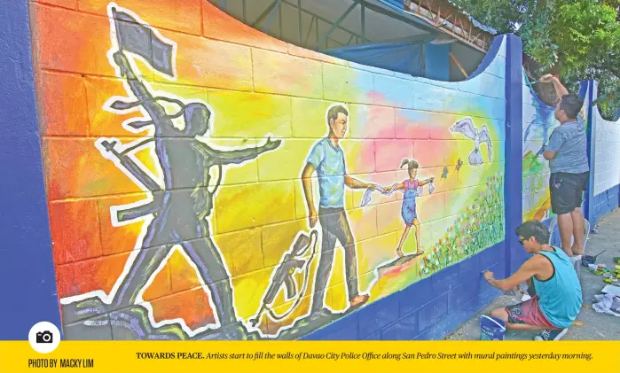  ?? PHOTO BY MACKY LIM ?? TOWARDS PEACE. Artists start to fill the walls of Davao City Police Office along San Pedro Street with mural paintings yesterday morning.