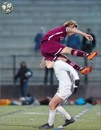  ?? SARAH GORDON/THE DAY ?? East Lyme’s Alec Kosinski sails over the back of Ledyard’s Cole Dirico after the two collided while battling for possession during Tuesday’s ECC Division I boys’ soccer semifinal at New London. The second-seeded Vikings beat the No. 3 Colonels 2-1 in sudden death overtime to reach Thursday’s final.