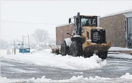  ?? DAVE JOHNSON THE WELLAND TRIBUNE ?? A front-end loader clears the entrance and exit of the City of Welland-owned parking lot beside King Street fire hall Wednesday morning.