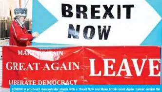  ?? — AFP ?? LONDON: A pro-Brexit demonstrat­or stands with a ‘Brexit Now and Make Britain Great Again’ banner outside the Supreme Court in central London.